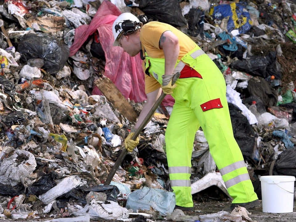 Zu sehen ist ein Arbeiter auf einer Müllhalde.