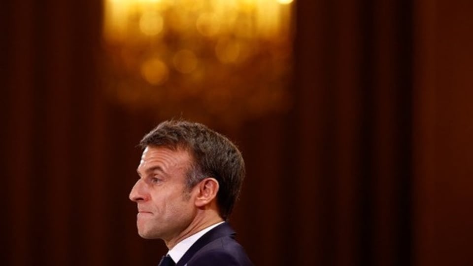 Der Kopf von Emmanuel Macron. Im Hintergrund ist ein besonderes gelbes Licht zu sehen.