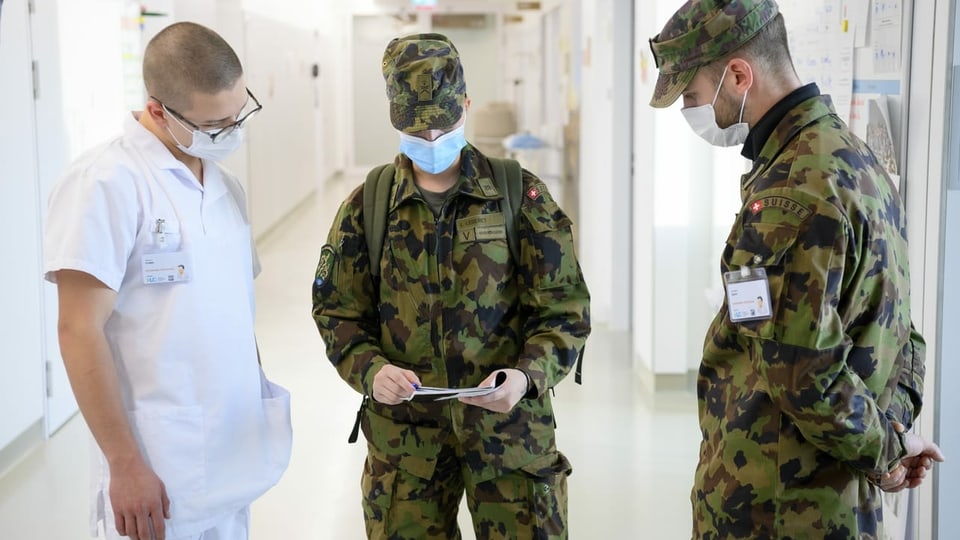 Zwei Soldaten und ein Arzt im Gespräch