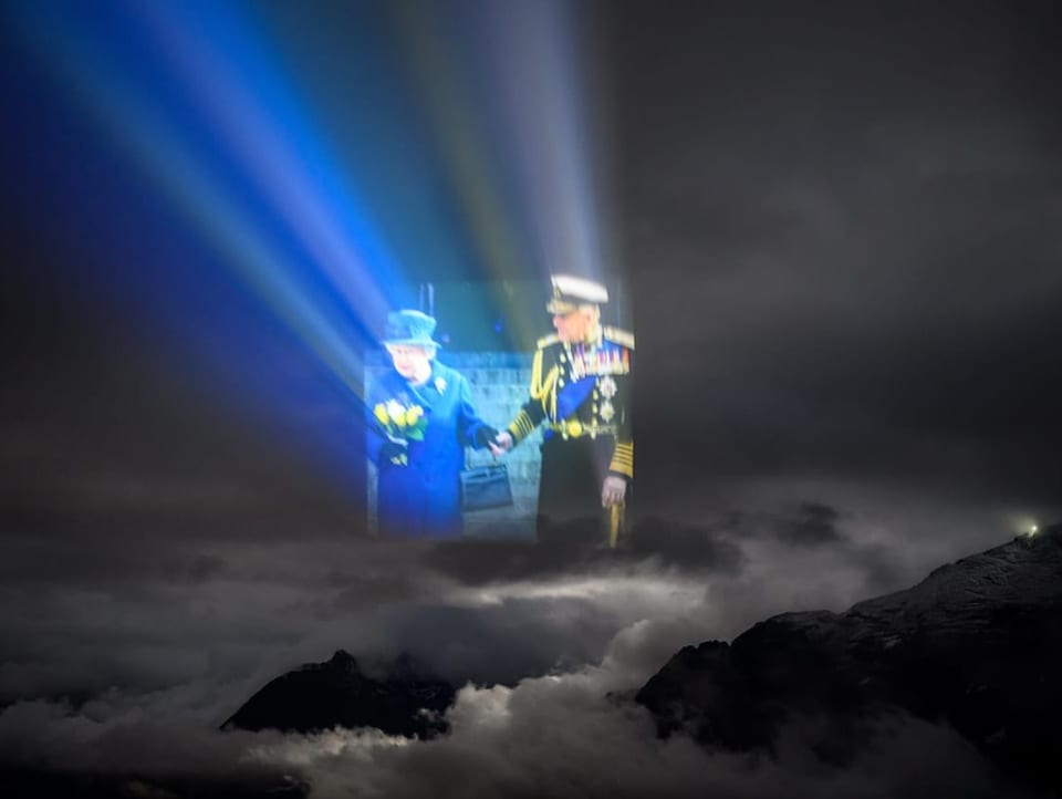 Queen Elizabeth und Prinz Philipp als Projektion in den Wolken 