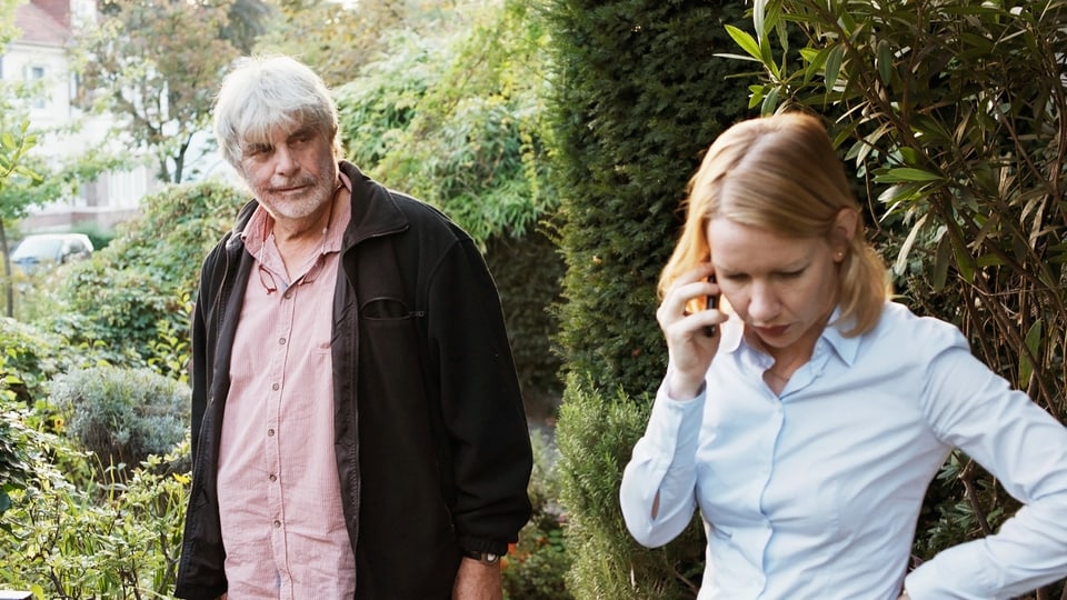Man (left) and woman (right), woman talking on the phone.