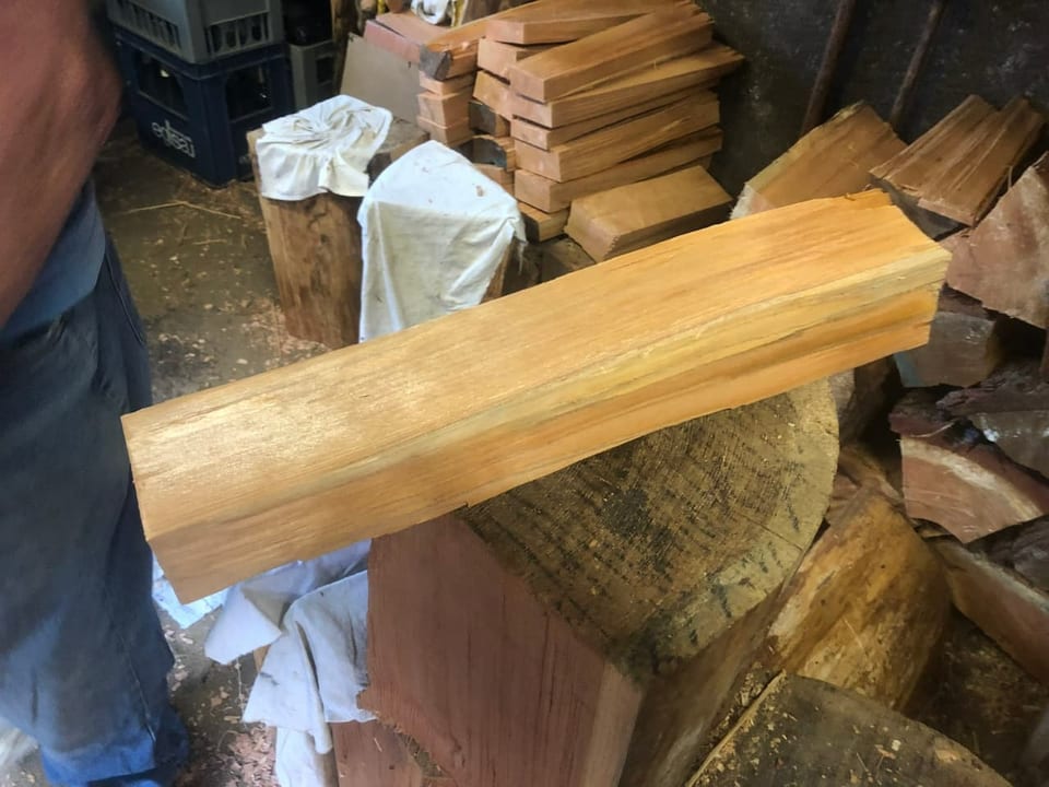 Ein Stück Holz liegt auf einem Spaltstein.