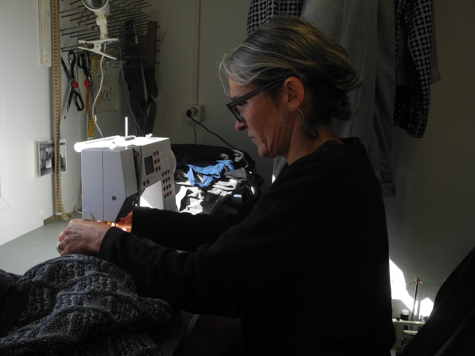 Kathrin Widmer sitzt an einer Nähmaschine und flickt ein Kostüm.