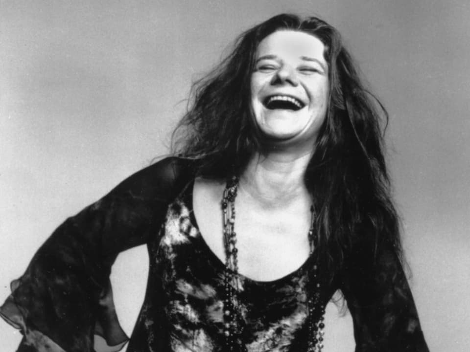 Janis Joplin performt und sing ins Mikro.