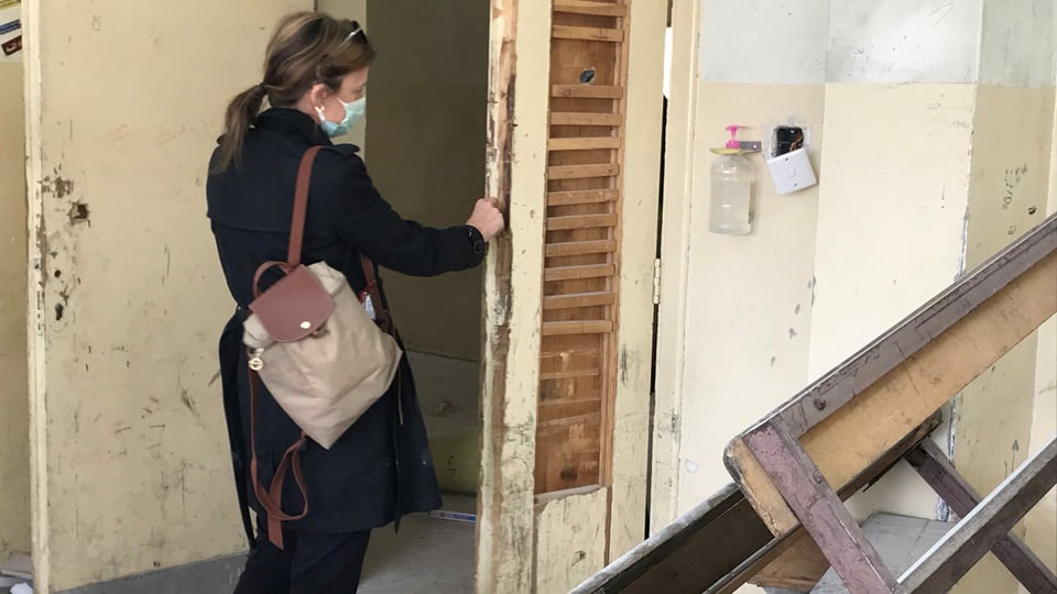 Bauführerin Jill Schmidheiny untersucht die schwer beschädigte Türe zu einem Klassenzimmer in einer Knabenschule in Zarqa