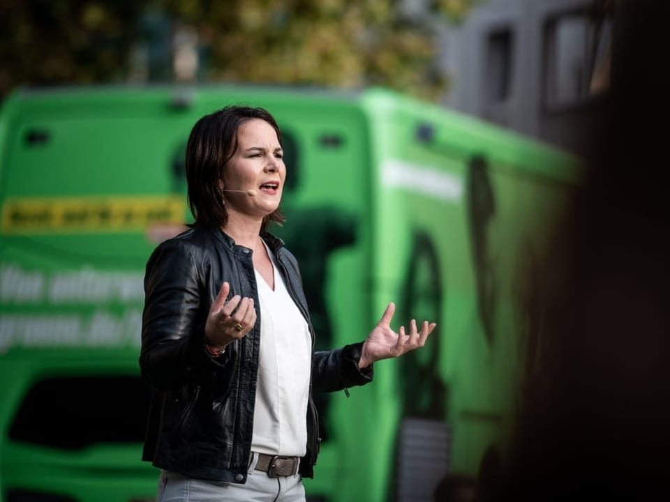 Annalena Baerbock spricht an einem Wahlkampftermin von einem Wahlkampfbus.