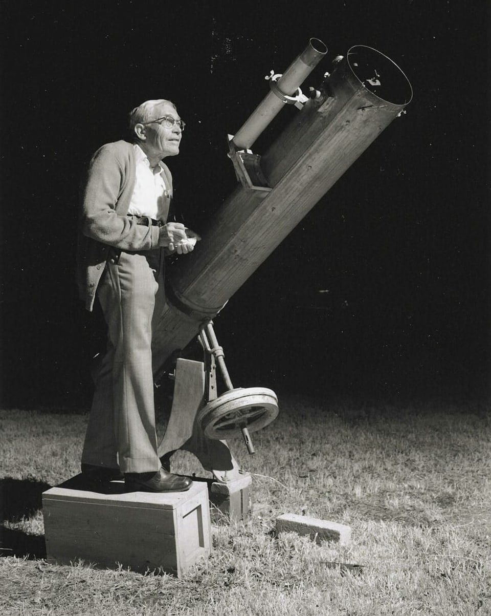 Clyde Tombaugh schaut in ein Teleskop.