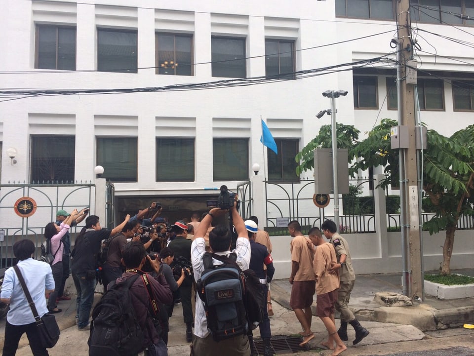 Journalisten stürzen sich auf Gefangene, die beim Militärgericht in Bangkok ankommen.