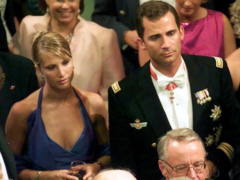 Eva Sannum in blauem Abendkleid und Felipe in Uniform in einer Menschenmenge stehend.