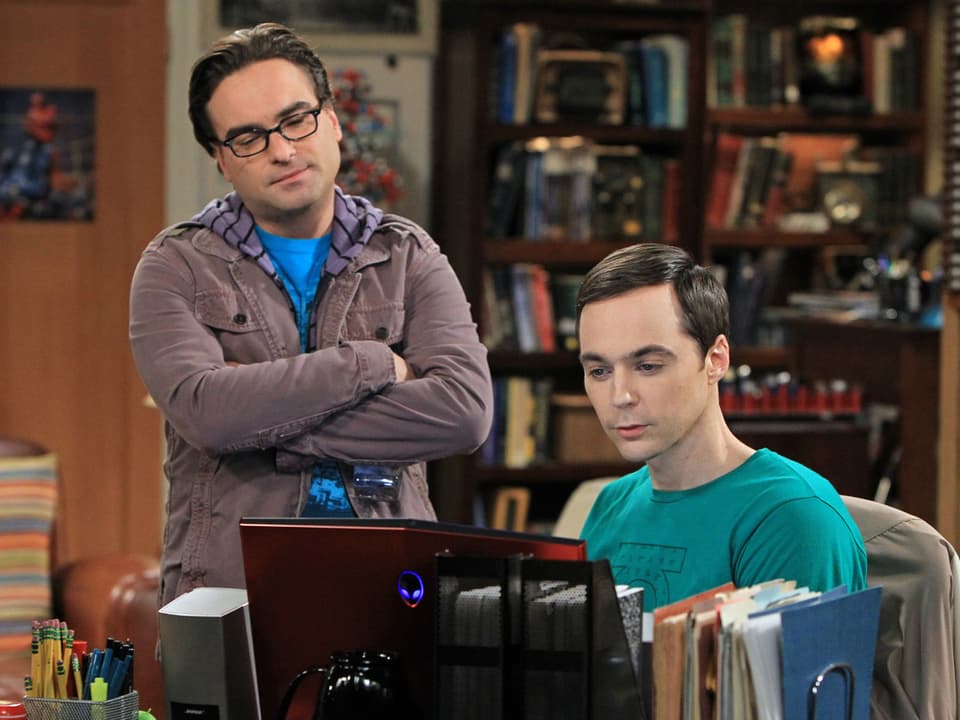 Szene aus der TV-Serie: Zwei Männer schauen auf einen Laptop.