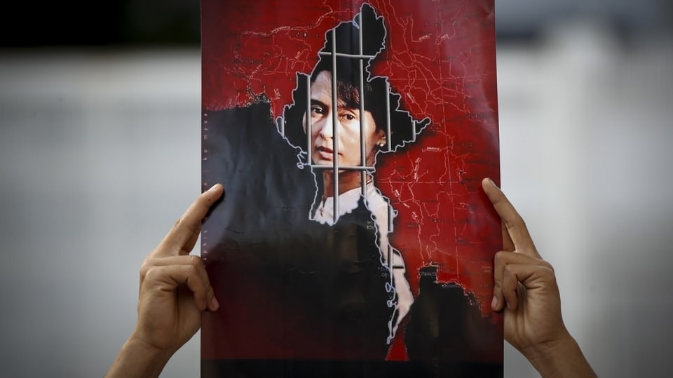 Mann hält Bild von Aung San Suu Kyi in die Luft