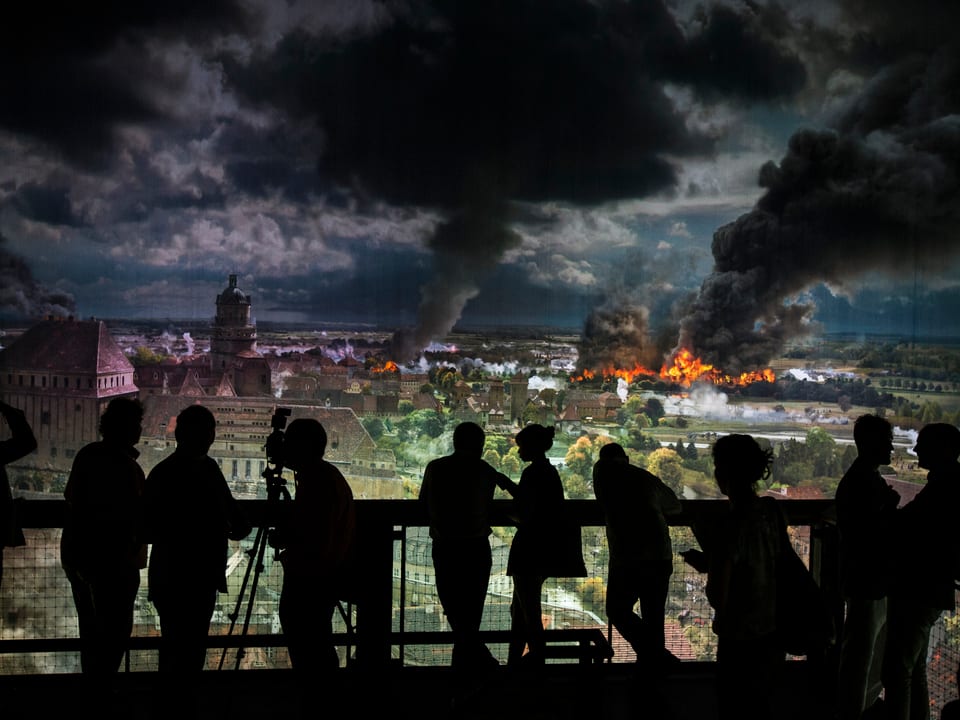 Besucher der Feier schauen sich ein Panorama-Bild der Völkerschlacht von Leipzig an, es ist nachgestellt. 