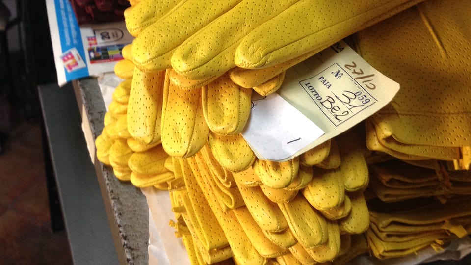 Mehrere Paare gelber Lederhandschuhe liegen auf einem Stapel.
