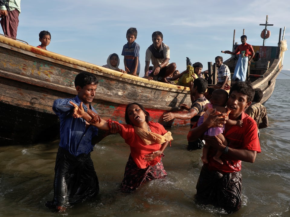 Rohingya-Flüchtlinge steigen an der Küste von Bangladesch aus einem Boot.