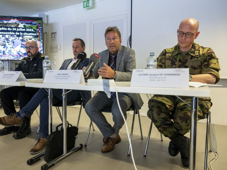 Armeeoberst Jacques de Chambrier (rechts), der Neuenburger Regierungspräsident Alain Ribaux (2. v. rechts) informierten informierten gemeinsam mit weiteren Verantwortlichen in La Chaux-de-Fonds über den Stand der Aufräumarbeiten.