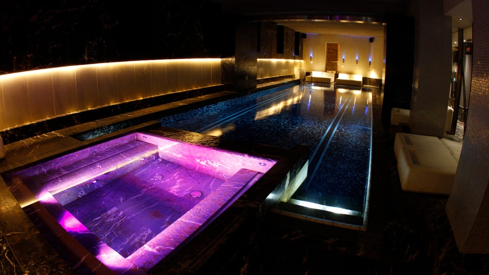 Ein bunt beleuchteter Swimming Pool in einem Hotel.