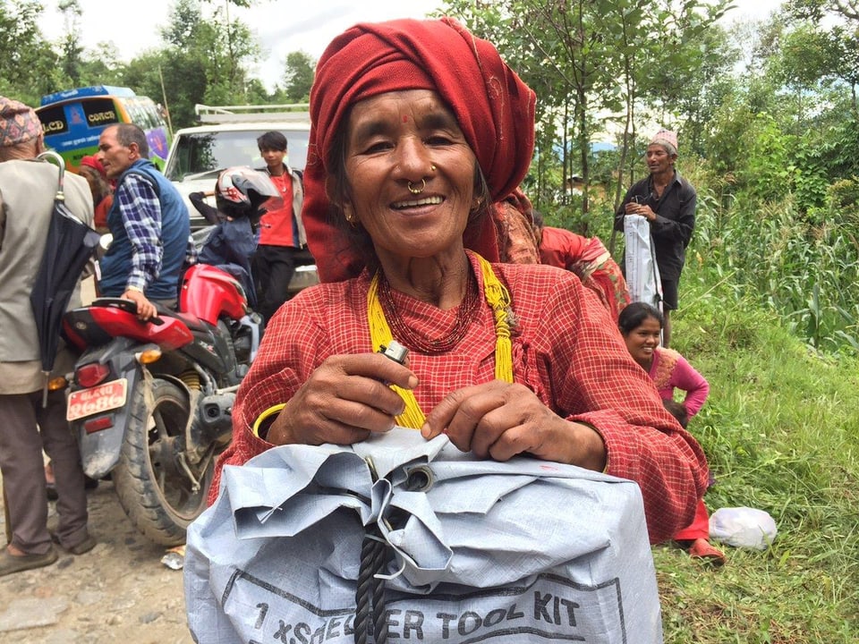 Eine lachende Frau mit einem Hilfspaket