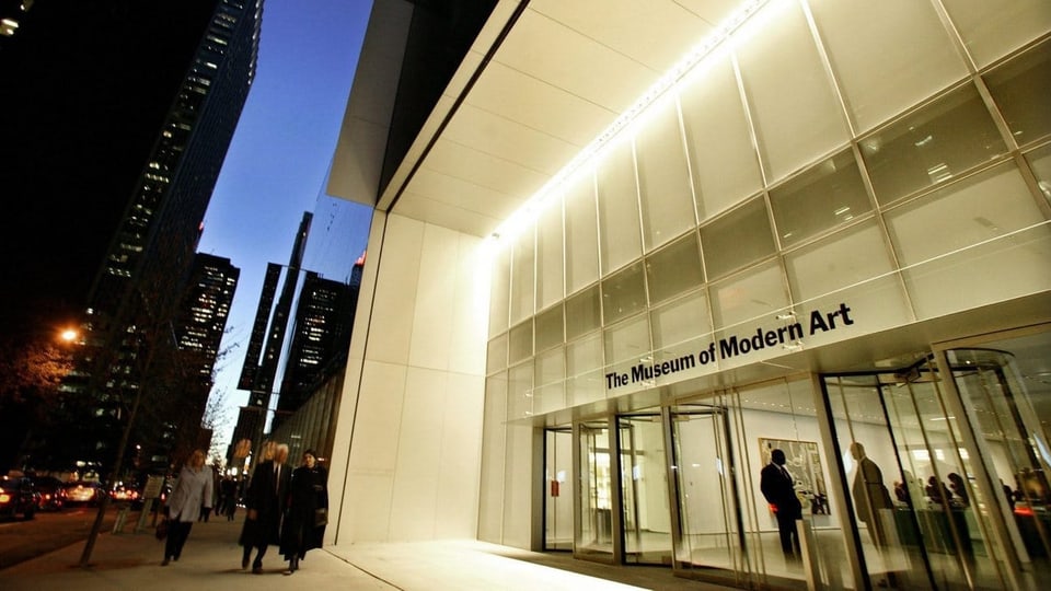 Das Museum of Modern Art in New York, fotografiert in der Dämmerung mit dunkelblauem Himmel.