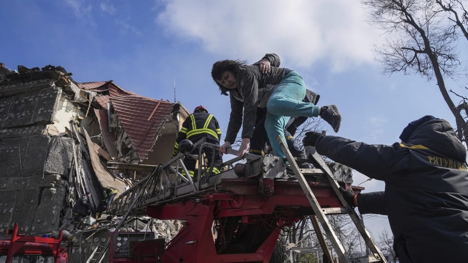 Eine Frau wird von der Feuerwehr gerettet, nachdem ihr Haus bombardiert wurde (10. März).