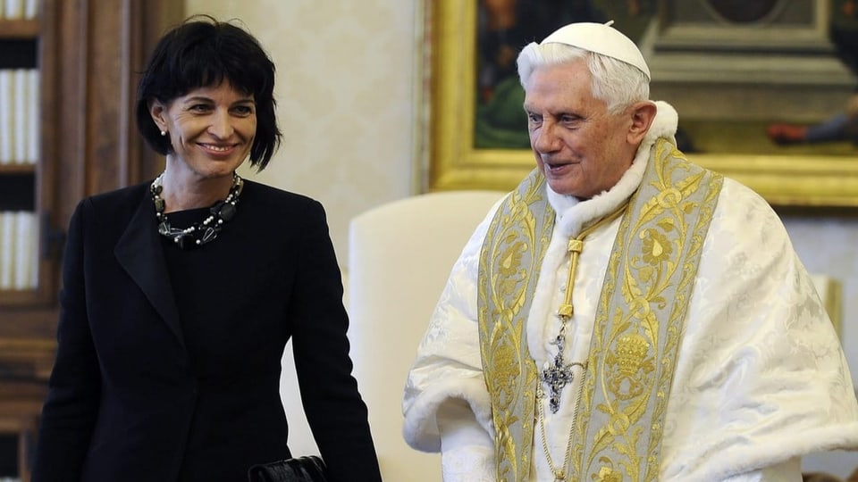 Leuthard steht neben dem Papst. Sie trägt schwarz. Er trägt weiss und gold.