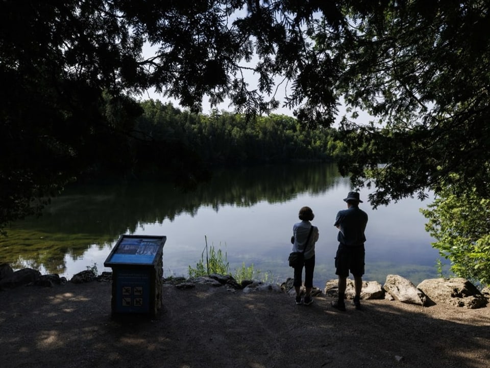 Zwei Personen stehen am Ufer des sommerlichen Craword Lakes und blicken über den See