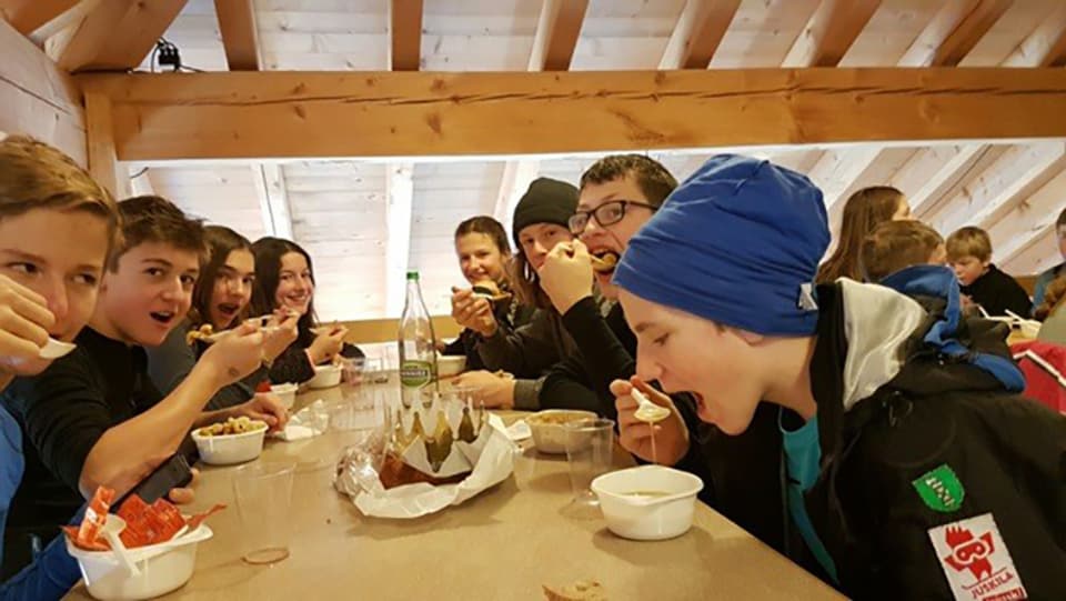 Kinder beim Mittagessen in einer Skihütte