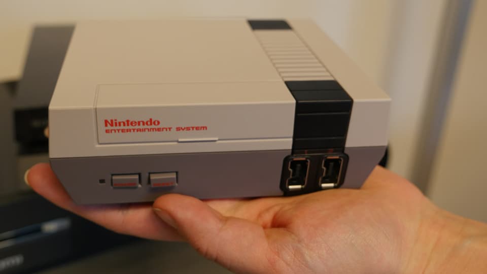 Eine Hand, auf der die Nintendo Mini Classic liegt.