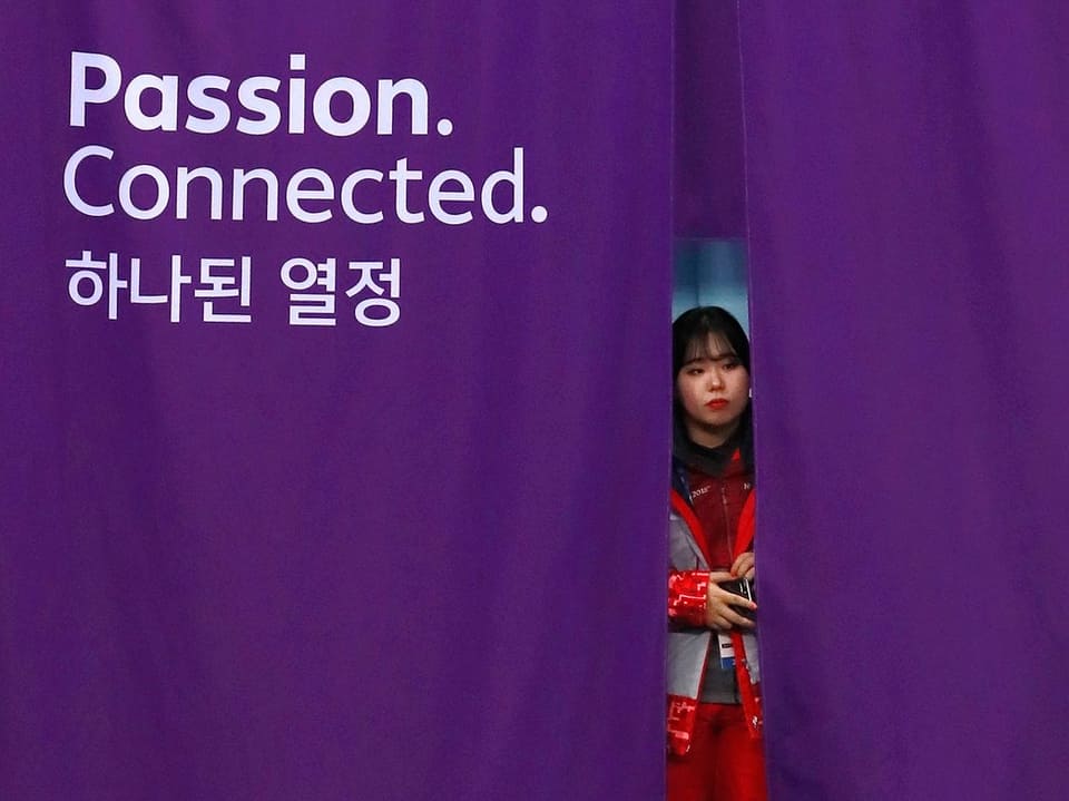 Südkoreanerin schaut hinter einem Vorhang hervor