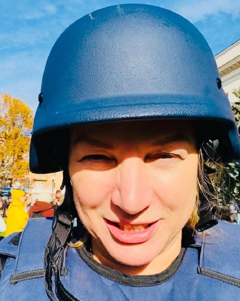 Tetiana Popova ist mit Helm und Schutzweste ausgestattet.