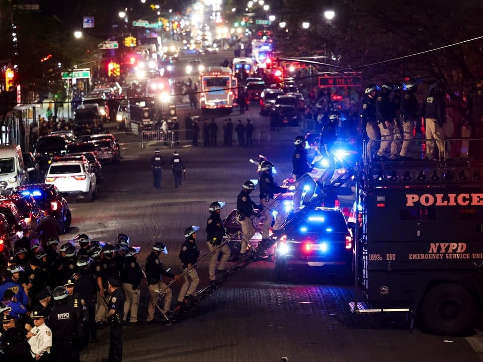 NYPD-Polizeieinsatz bei Nacht mit vielen Einsatzfahrzeugen und Beamten auf der Strasse.