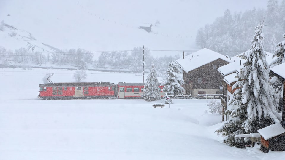 Zug fährt durch Winterlandschaft.
