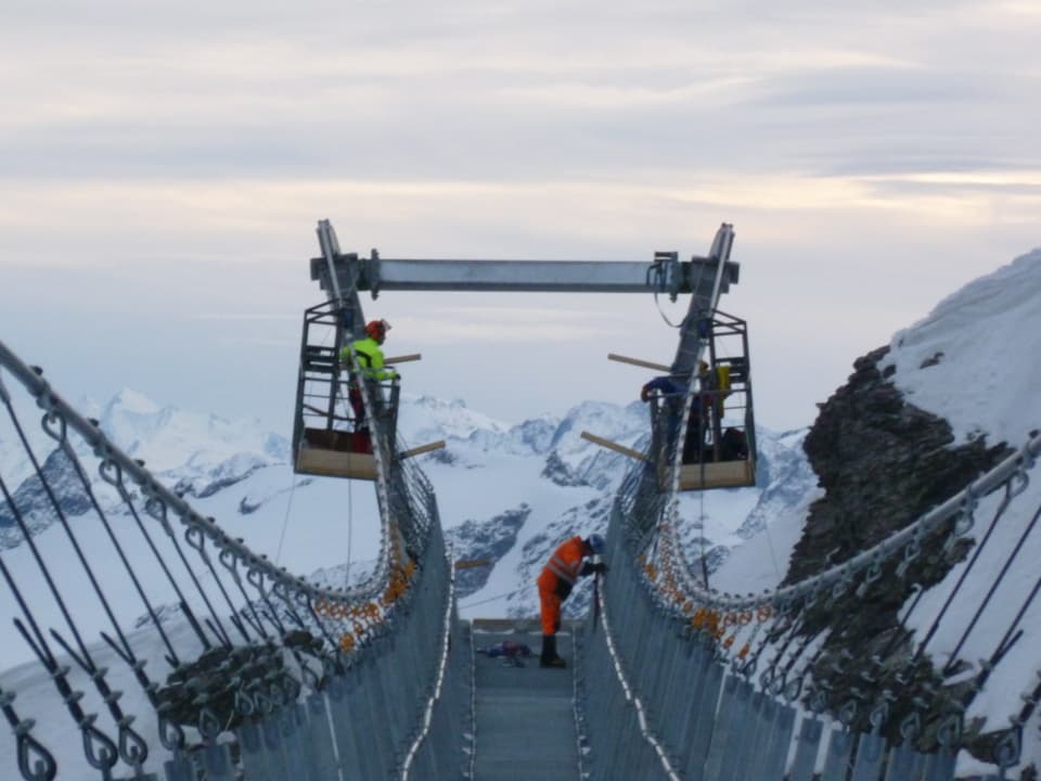 Arbeiter montieren die neue Hängebrücke auf dem Titlis.