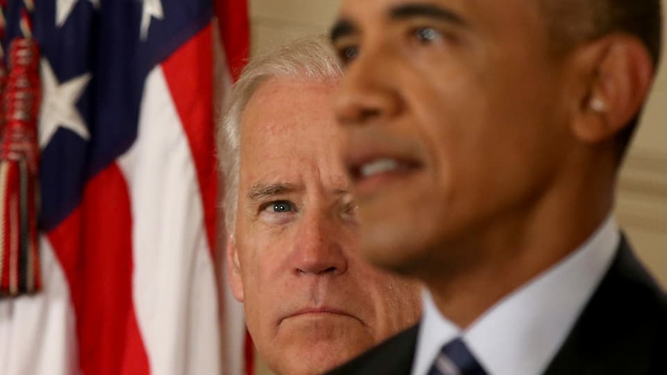 Obama im Hintergrund Joe Biden, der ihn beobachtet.