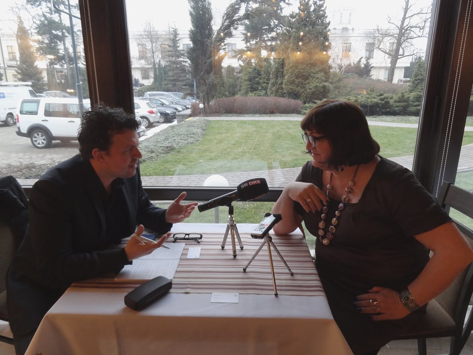 Marc Lehmann sitzt mit Anna Grodzka an einem Tisch am Fenster.