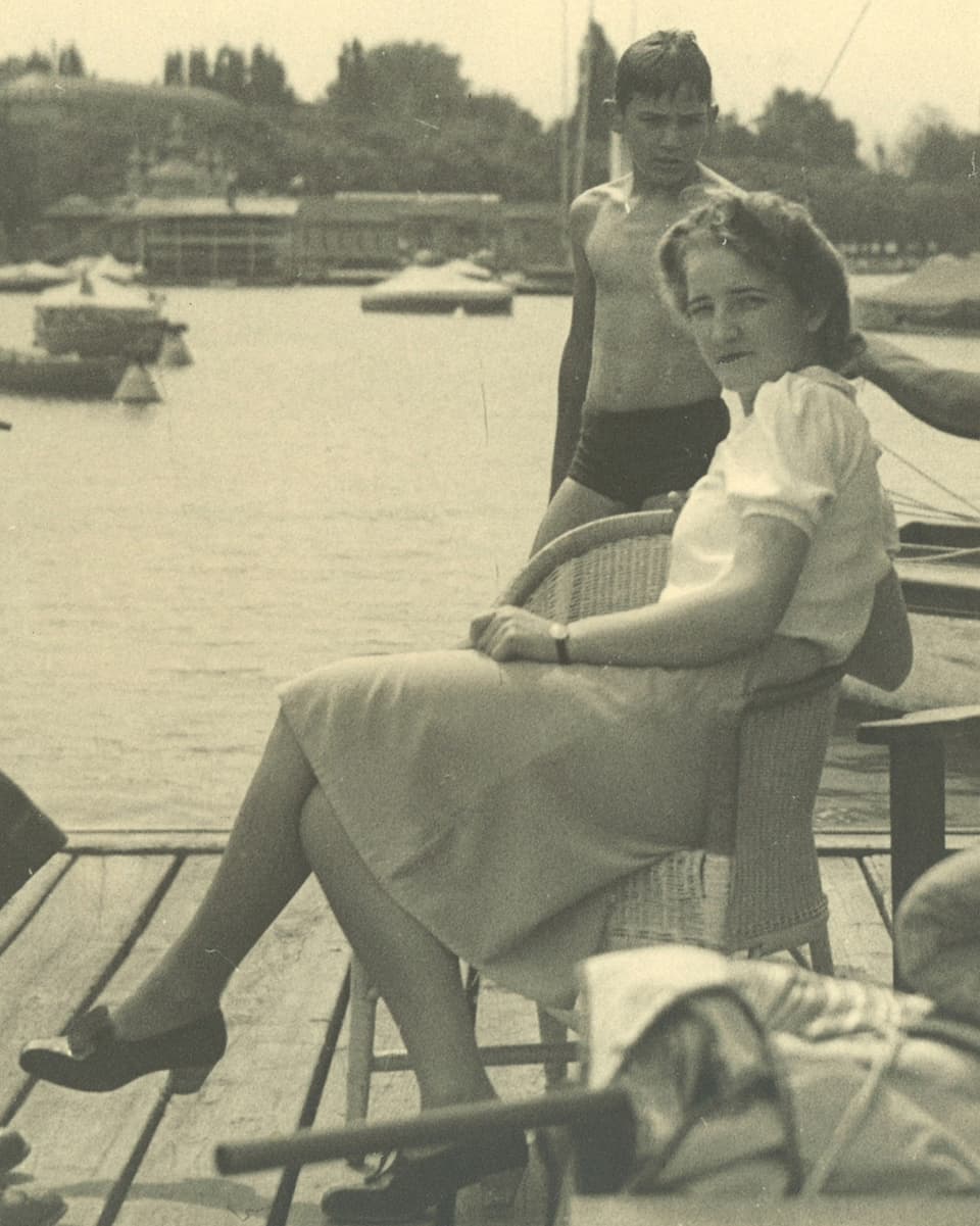 Alte Fotografie mit einer jungen Frau, die in einem Korbsessel sitzt.