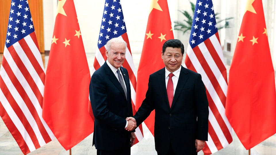 Biden und Xi geben sich vor chinesischen und amerikanischen Flaggen demonstrativ die Hand.