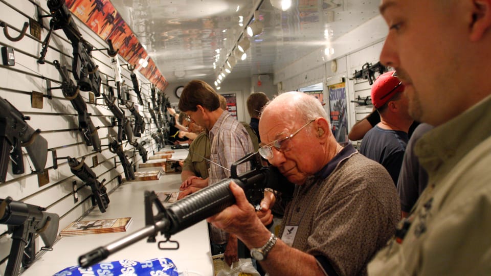 Ein Mann zielt in einem Geschäft mit einem Gewehr