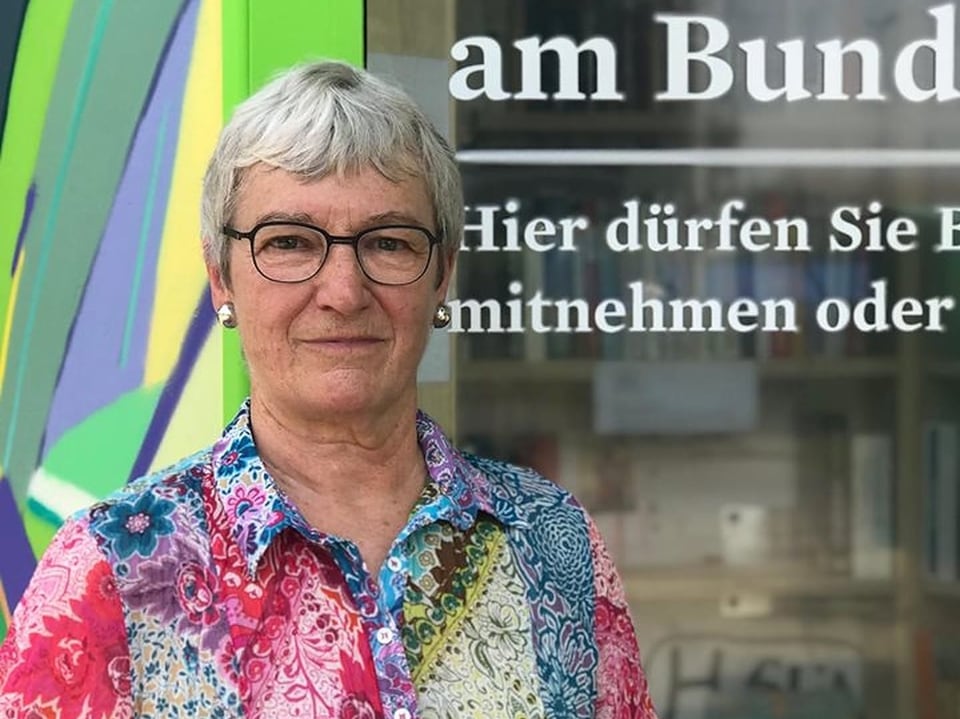 Eine ältere Frau steht vor der Telefonkabine. Sie hat das Projekt vorangetrieben und hofft, dass die Bücherkabine zu einem sozialen Treffpunkt wird.