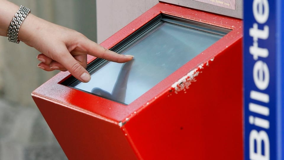 Eine Frauenhand bedient einen SBB-Billett-Automaten