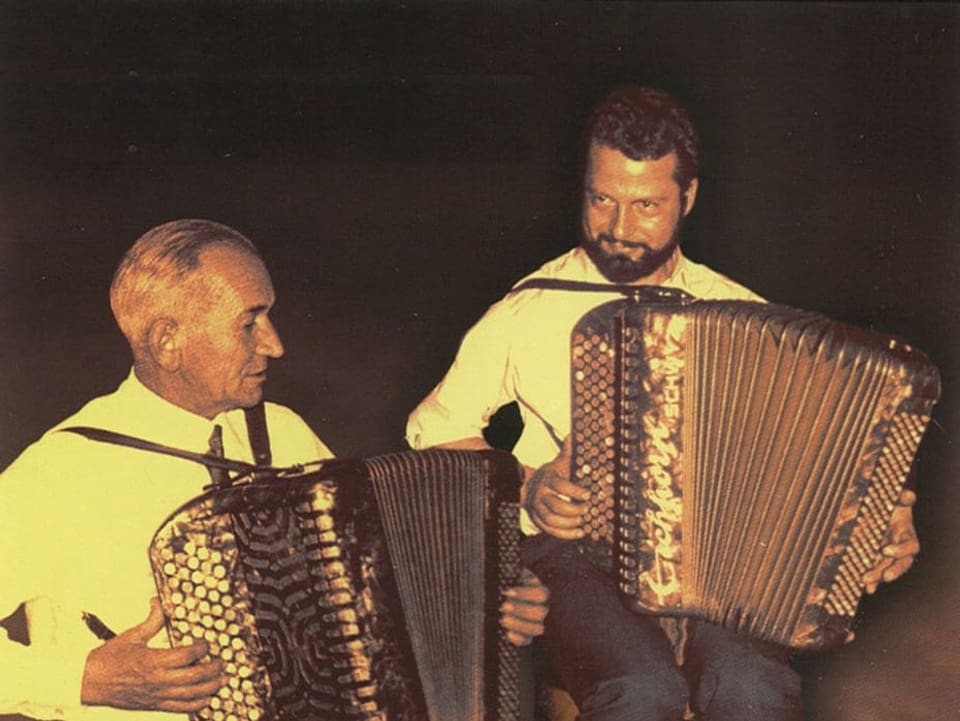 Die beiden Musiker spielen sitzend auf dem Akkordeon.