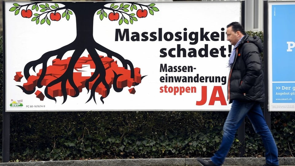 Plakat der Befürworter der SVP-Volksinitiative "gegen Masseneinwanderung", davor geht ein Mann vorbei. Aufgenommen in Zürich.