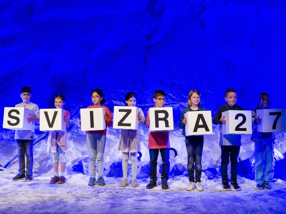 Kinder mit einzelnen Buchstaben auf kleinem Plakat: Svizera27
