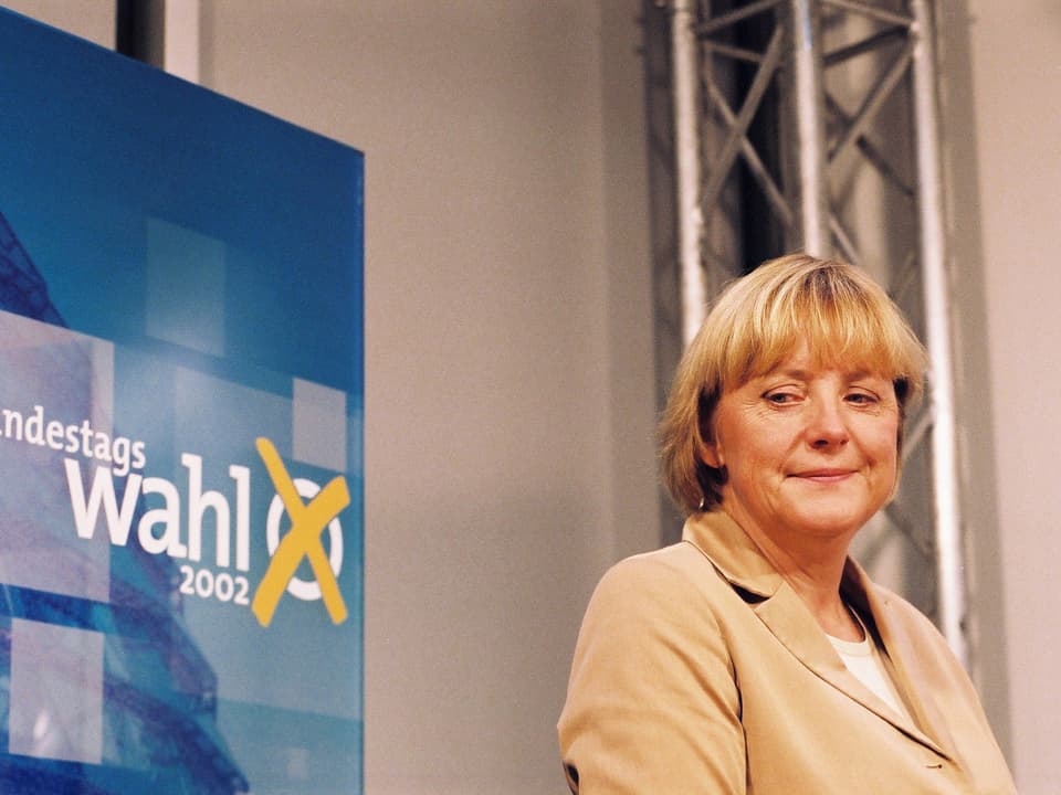 Angela Merkel vor einem Wahlplakat. 