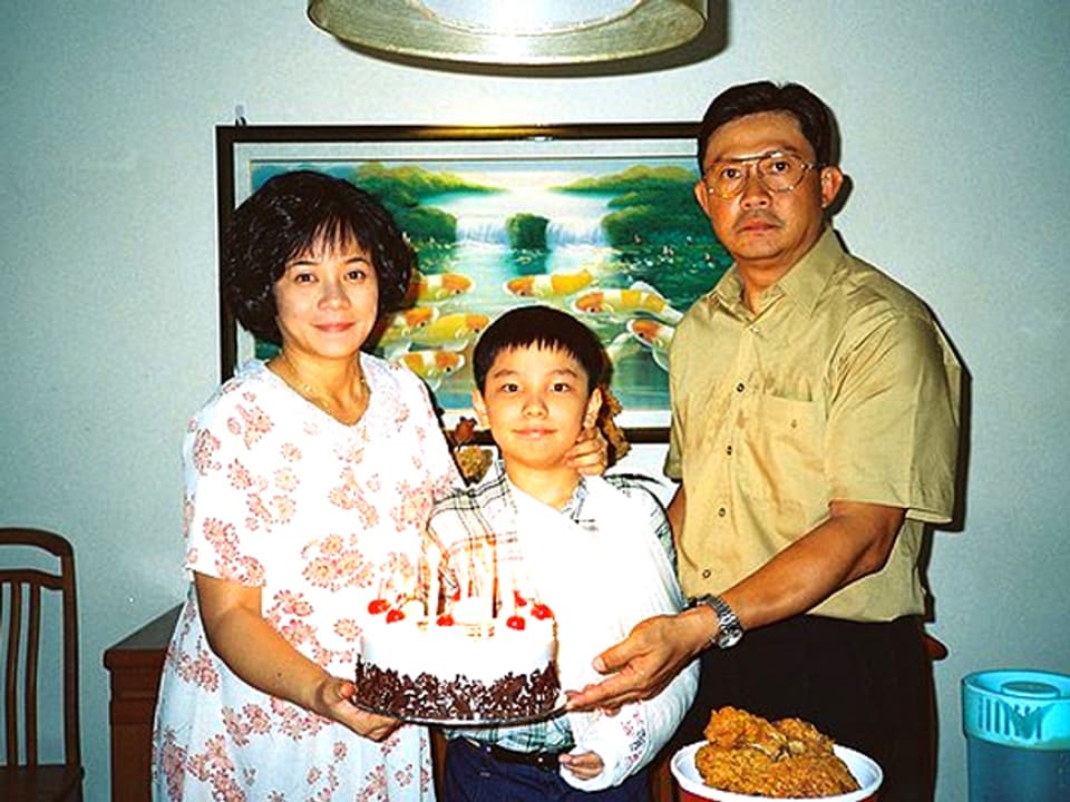 Mutter, Vater und Kind mit Geburtstagstorte.