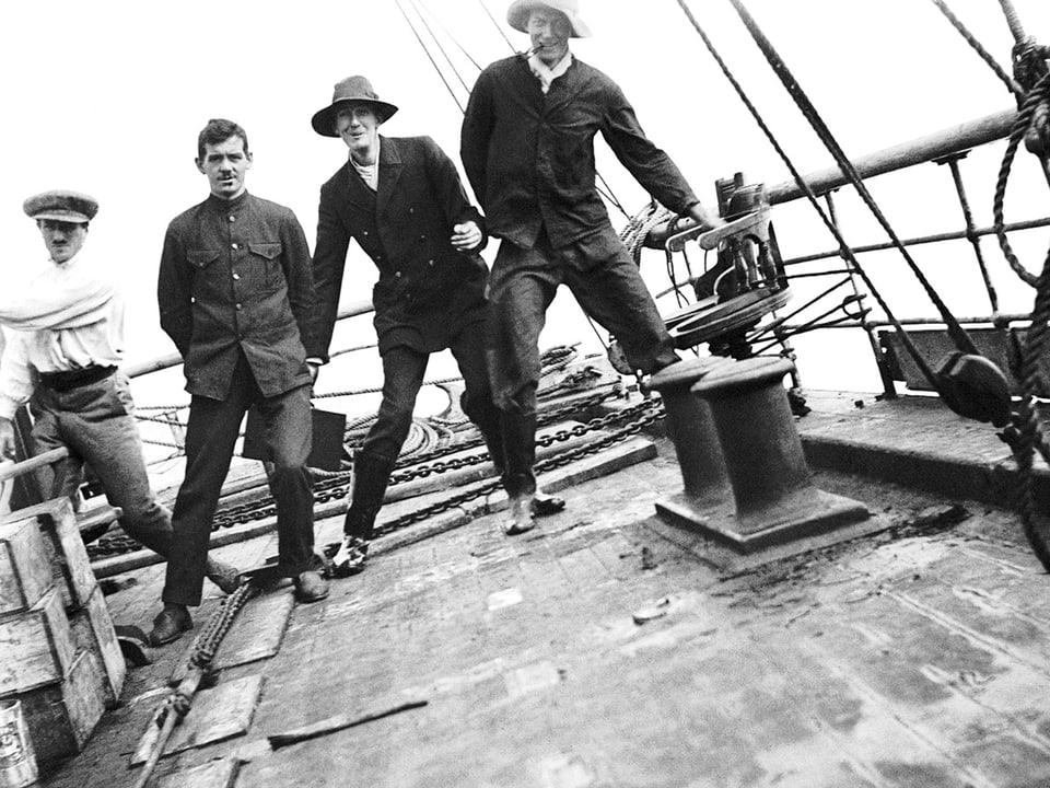 Vier Männer posieren auf dem Schiff vor der Kamera.