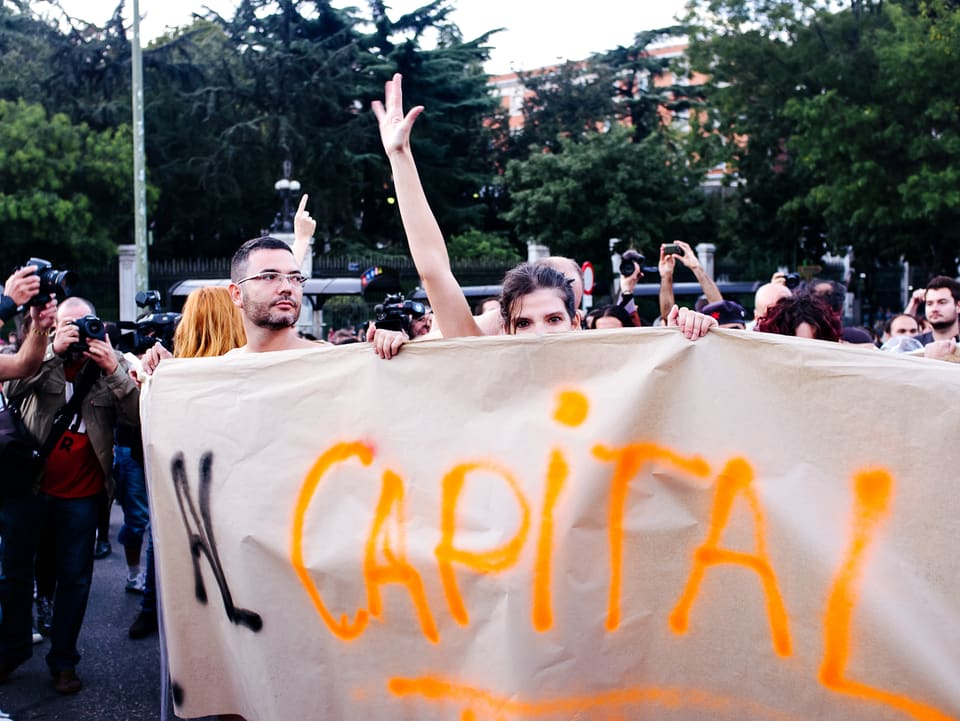 Protestierende werden von Fotografen abgelichtet, als sie auf der Plaza Del Carmen mit einem grossen Banner eine Kundgebung veranstalten. 