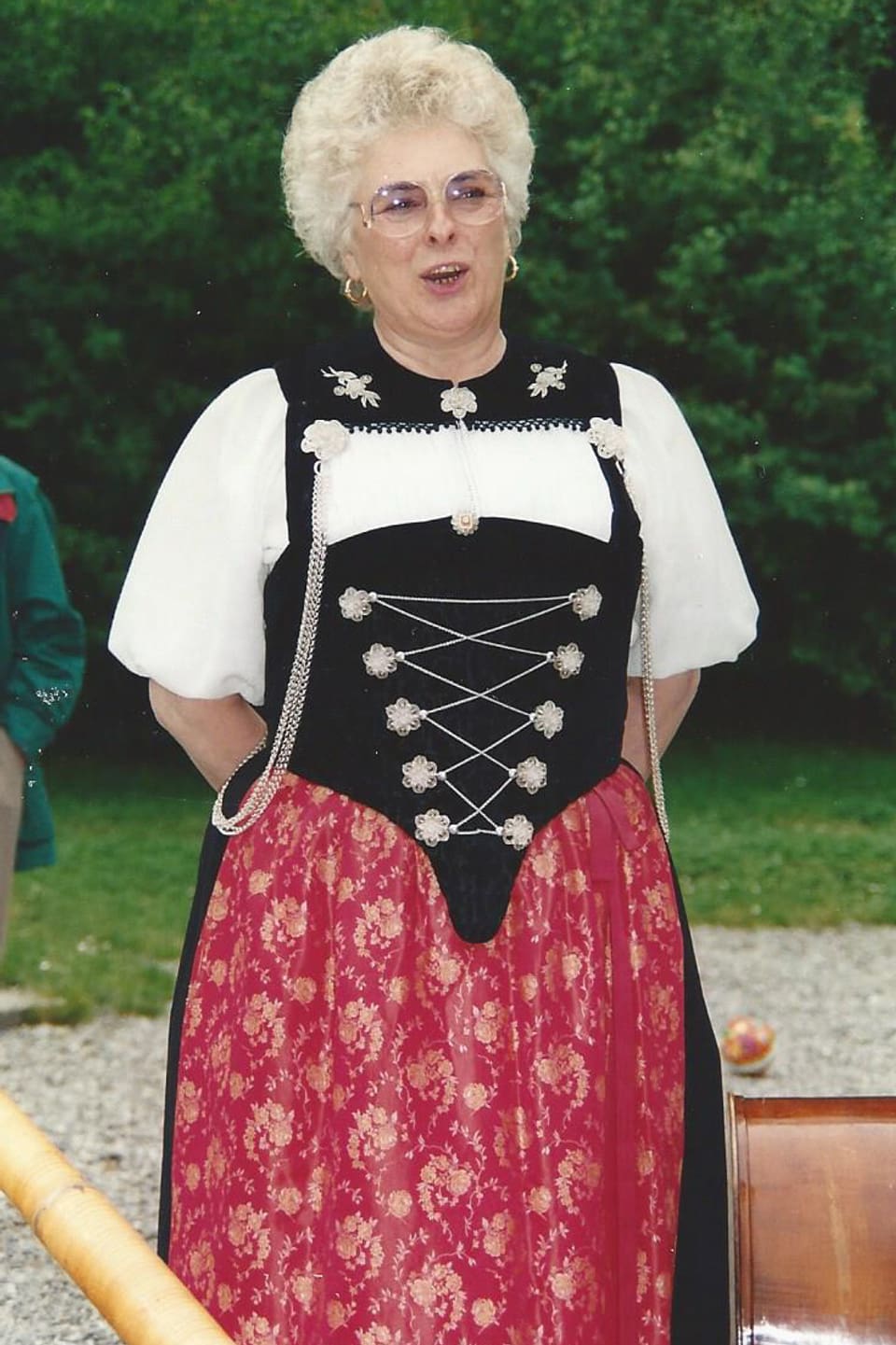 Eine ältere Jodlerin, die eine Tracht trägt und singt.
