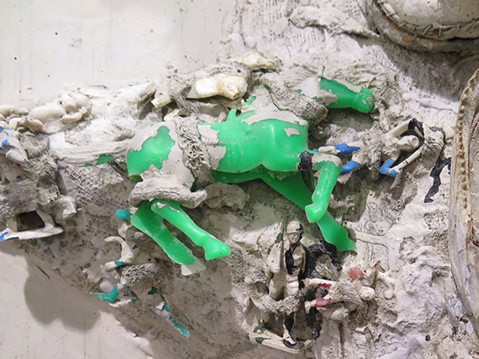 Weisse Kunstinstallation mit grünem Plastikpferd. 