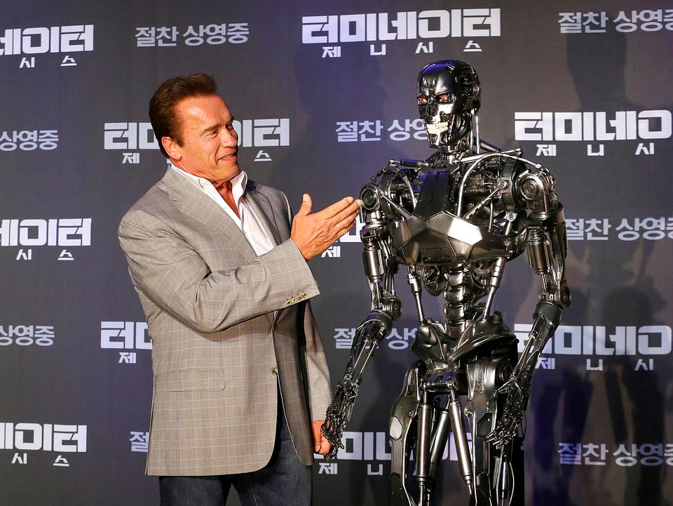 Arnold Schwarzenegger neben einem Roboter stehend