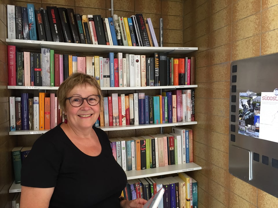 Die Verantwortliche der Mini-Bibliothek im Linsebühlquartier, Ruth Lauper, steht vor den Bücherregalen.